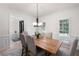Bright dining room with a rustic wooden table and views of the front yard at 410 Beechwood Ln, Woodstock, GA 30189