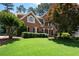 Beautiful two-story brick home featuring a well-manicured lawn and mature trees at 410 Beechwood Ln, Woodstock, GA 30189