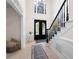 Spacious foyer with elegant staircase and light hardwood floors leading to the front door at 410 Beechwood Ln, Woodstock, GA 30189