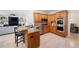 Kitchen featuring stainless steel appliances, granite counters, wood cabinetry, and open access to the dining and living areas at 410 Beechwood Ln, Woodstock, GA 30189