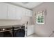 Bright laundry room features Samsung washer/dryer, sink, and white cabinetry for a functional space at 410 Beechwood Ln, Woodstock, GA 30189