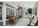 Cozy screened porch with stylish wicker furniture, tile flooring, and serene outdoor views at 410 Beechwood Ln, Woodstock, GA 30189