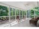 Relaxing screened porch with tile flooring, ceiling fan, and wooded views for outdoor enjoyment at 410 Beechwood Ln, Woodstock, GA 30189