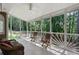 Inviting screened porch with tile flooring, ceiling fan, and comfortable seating overlooking lush greenery at 410 Beechwood Ln, Woodstock, GA 30189