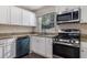Stylish kitchen boasts granite countertops, white cabinets, stainless steel appliances and hardwood floors at 726 Alfred Nw Rd, Atlanta, GA 30331