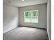 Inviting bedroom with plush carpeting and a window overlooking the greenery outside at 112 Scarlett Place Dr, Bowdon, GA 30108