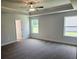 A spacious bedroom with a ceiling fan, large windows, and plush carpet flooring at 112 Scarlett Place Dr, Bowdon, GA 30108