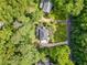 Aerial view of a home nestled among mature trees, showcasing its manicured landscaping and driveway at 2502 Tritt Springs Ne Trce, Marietta, GA 30062