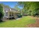 Manicured backyard with a screened in porch, steps to the yard, level lawn, and mature trees at 2502 Tritt Springs Ne Trce, Marietta, GA 30062