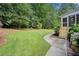 A spacious backyard features lush green grass, mature trees, and a charming screened porch with wooden steps at 2502 Tritt Springs Ne Trce, Marietta, GA 30062