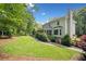 Spacious backyard featuring a screened in porch with stairs to the yard, a lawn, and mature trees at 2502 Tritt Springs Ne Trce, Marietta, GA 30062