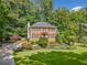 Classic brick home with black shutters, lovely landscaping, and a serene, wooded backdrop at 2502 Tritt Springs Ne Trce, Marietta, GA 30062