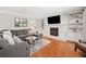 Cozy living room with hardwood floors, comfortable sectional, fireplace, and built-in shelving at 2502 Tritt Springs Ne Trce, Marietta, GA 30062