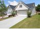 Side view of cozy home showing tidy lawns, attractive plantings, and long driveway to the two-car garage at 4571 Grenadine Cir, Acworth, GA 30101