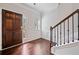 Warm foyer featuring hardwood floors, paneled walls, and a staircase with dark wood railing at 4571 Grenadine Cir, Acworth, GA 30101