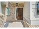 View of the attractive front entrance featuring brickwork, a dark wood door, and a charming light fixture at 4571 Grenadine Cir, Acworth, GA 30101