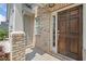 Close up of beautiful brick facade with dark wood door and sidelight, leading to front porch at 4571 Grenadine Cir, Acworth, GA 30101