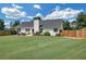 This backyard features a lush lawn, a patio with furniture, and a fence with mature trees at 5105 Ashley Falls Ct, Loganville, GA 30052