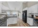 Open kitchen featuring white cabinets, stainless appliances, granite countertops, and wood flooring at 5105 Ashley Falls Ct, Loganville, GA 30052
