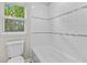 Bright bathroom with white tile, and natural light coming from a window at 1179 Chatham Rd, Buford, GA 30518