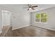 A light-filled bedroom with wood-look flooring, a ceiling fan, and a large window at 1179 Chatham Rd, Buford, GA 30518