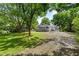 Serene front exterior surrounded by trees, gravel driveway leading to home at 1179 Chatham Rd, Buford, GA 30518