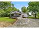 Charming home featuring a covered front porch, landscaped greenery, side carport, with a well-manicured lawn and mature trees at 1179 Chatham Rd, Buford, GA 30518