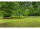 Lush front yard featuring mature trees providing shade and privacy at 1179 Chatham Rd, Buford, GA 30518