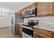 This kitchen offers stainless steel appliances, light wood cabinetry, and granite countertops at 1179 Chatham Rd, Buford, GA 30518