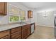 The kitchen features wood cabinets, stainless steel appliances, and a double bowl sink under a large window at 1179 Chatham Rd, Buford, GA 30518