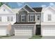 Charming townhome featuring a two-car garage, stone accents, and a mix of gray and white siding at 2490 Ravencliff Dr # 150, Austell, GA 30168