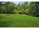 Large grassy backyard featuring a trampoline and other play equipment at 4341 Horder Ct, Snellville, GA 30039