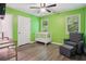 Well-lit bedroom featuring wood floors, ceiling fan, a crib, and an accent chair at 4341 Horder Ct, Snellville, GA 30039