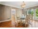 Bright dining room featuring wood floors, a glass-top table with seating for six, and a large picture window at 4341 Horder Ct, Snellville, GA 30039