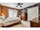 Comfortable bedroom featuring brick accent wall, neutral carpet, and ceiling fan at 2505 Ridgehurst Dr, Buford, GA 30518