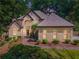 Stunning two-story home features a lush landscaped yard, stone pathway, and elegant architectural details at 2505 Ridgehurst Dr, Buford, GA 30518