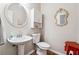 Half bath featuring pedestal sink, toilet, and decorative mirror on the wall at 2505 Ridgehurst Dr, Buford, GA 30518