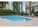 A luxurious pool surrounded by lounge chairs and high-rise buildings with tall trees at 3445 Stratford Rd # 3102, Atlanta, GA 30326