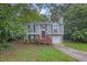 Charming split-level home with gray siding, brick accents, and a one-car garage nestled in lush greenery at 3498 Newberry Trl, Decatur, GA 30034