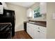 Well-lit kitchen featuring white cabinets, a black fridge, and a stainless steel sink at 3498 Newberry Trl, Decatur, GA 30034