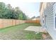 Large backyard with green grass, wooden fence, and a concrete patio, ideal for outdoor activities at 230 Mackenzie Ct, Covington, GA 30016