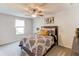 Comfortable bedroom features a ceiling fan, patterned bedding, and natural light from the window at 230 Mackenzie Ct, Covington, GA 30016