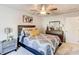 Well-lit bedroom features a ceiling fan, dresser, and comfortable bed with decorative pillows at 230 Mackenzie Ct, Covington, GA 30016