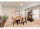 Bright dining room featuring neutral carpet, furniture, cabinet, a mirror, and natural light from the window at 230 Mackenzie Ct, Covington, GA 30016