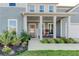 Inviting front porch with classic columns, a seating area, and a decorative wreath on the front door at 230 Mackenzie Ct, Covington, GA 30016