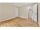 Bright bedroom featuring hardwood floors, neutral paint, white trim, and access to the hallway at 2552 Scenic S Hwy, Snellville, GA 30078