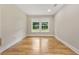 A well lit bedroom with hardwood floors, white trim, and a large window overlooking the property at 2552 Scenic S Hwy, Snellville, GA 30078