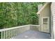 Gray back deck with a white railing, overlooks a heavily wooded backyard at 46 Highland Ct, Carrollton, GA 30116