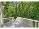 Back deck with white railing looks out onto wooded backyard at 46 Highland Ct, Carrollton, GA 30116