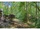 Sloping backyard leads into wooded area with mature trees and greenery at 46 Highland Ct, Carrollton, GA 30116